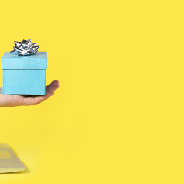 A hand reaching out of a computer holding a gift box